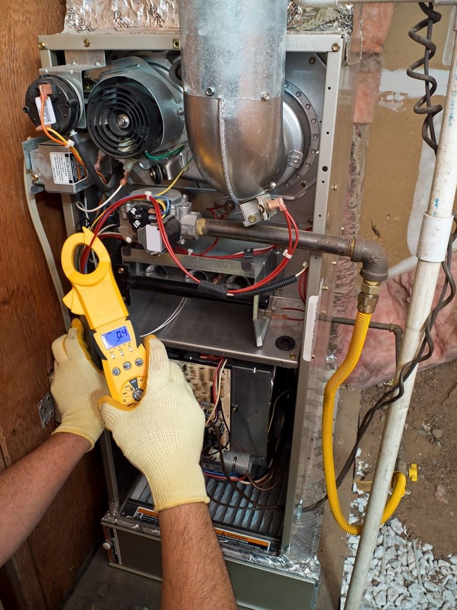 A furnace being professionally inspected by an HVAC technician